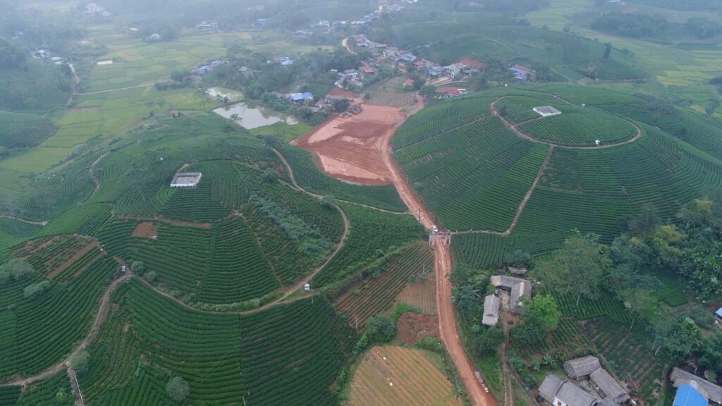 Luftaufnahme eines Teeanbaugebiets in Thai Nguyen und des Dorfes darunter