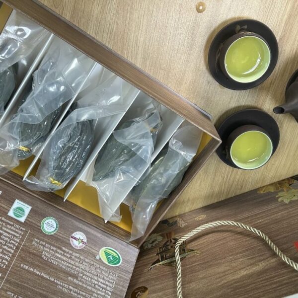 Caja de regalo Thanh Lien de TRAVINA en papel con aspecto de madera, abierta para mostrar los sobres de té