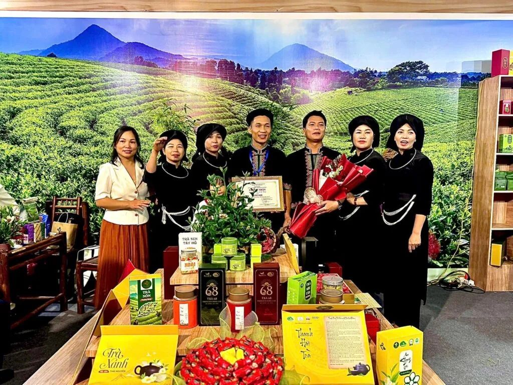 TRAVINA members holding the Golden Hands tea processing certificate at their booth, Thai Nguyen
