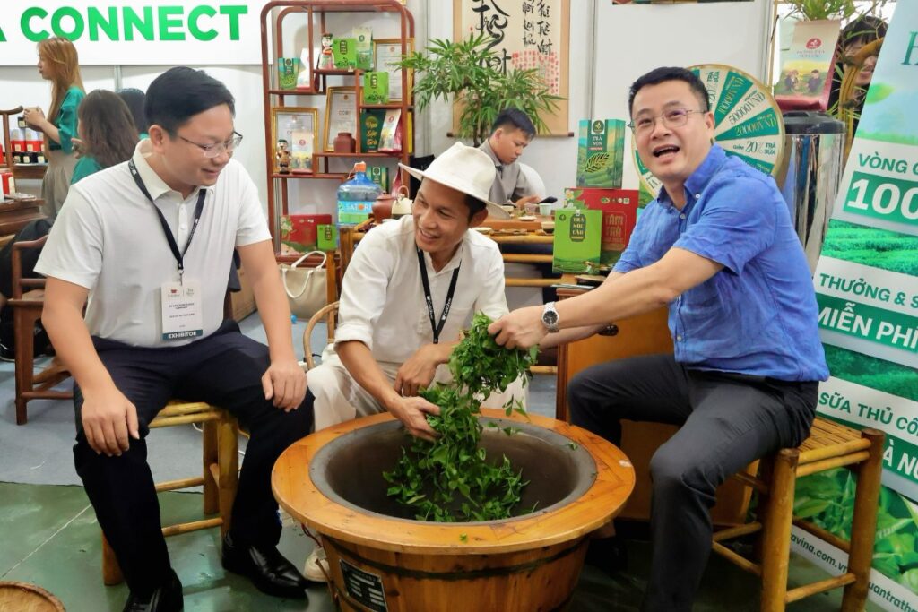 Visitor hand-roasting green tea leaves in a cast-iron pan